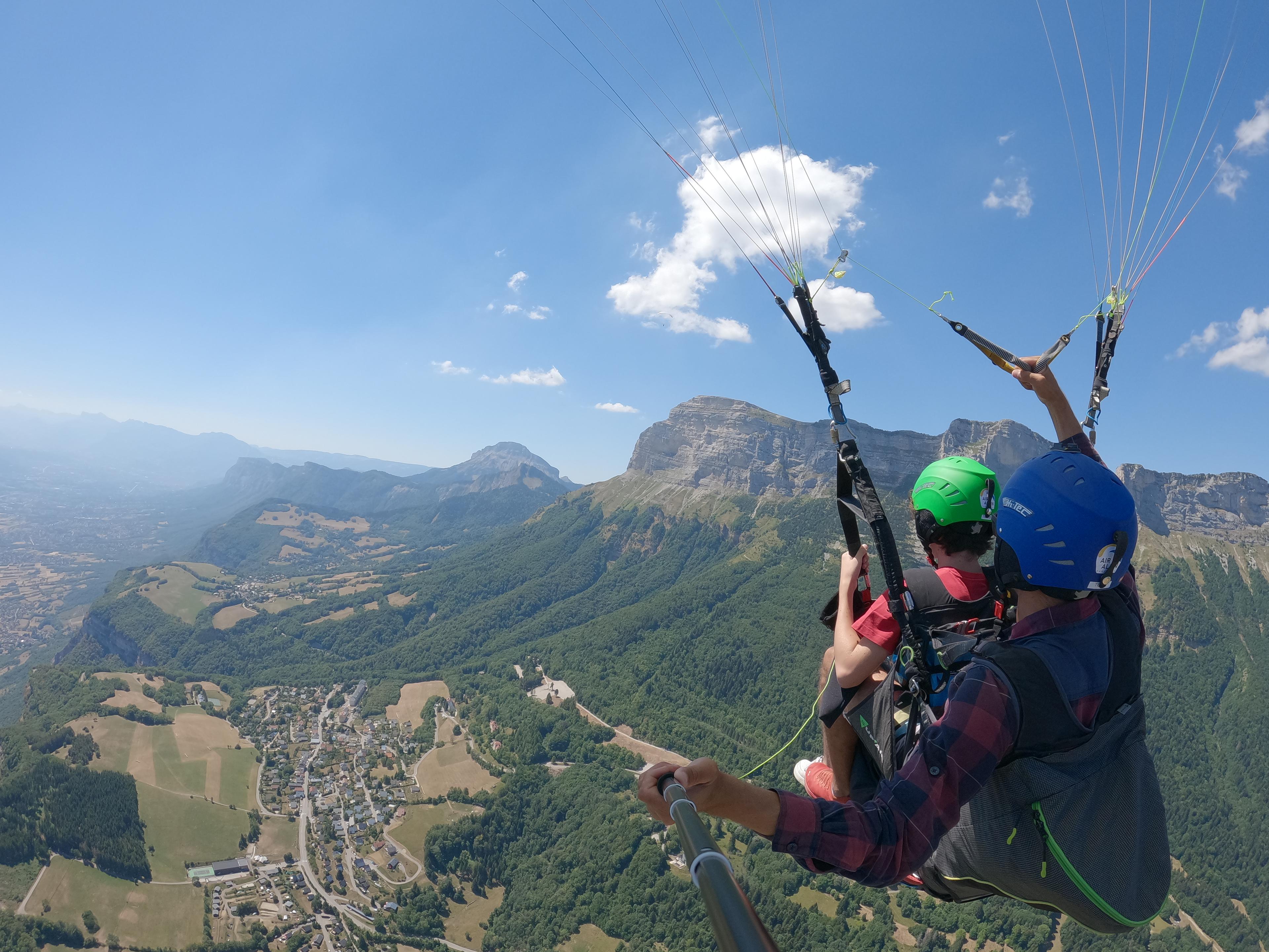 Biplace en parapente au dessus du plateau de Saint-Hilaire-du-Touvet, vue sur la dente de Crolles et Grenoble